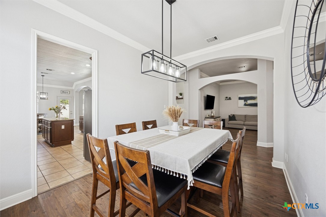 2309 First View Leander, TX 78641 - Photo 7 of 31 An inviting dining area sits beneath a modern light fixture and opens effortlessly toward both the kitchen and living spaces.