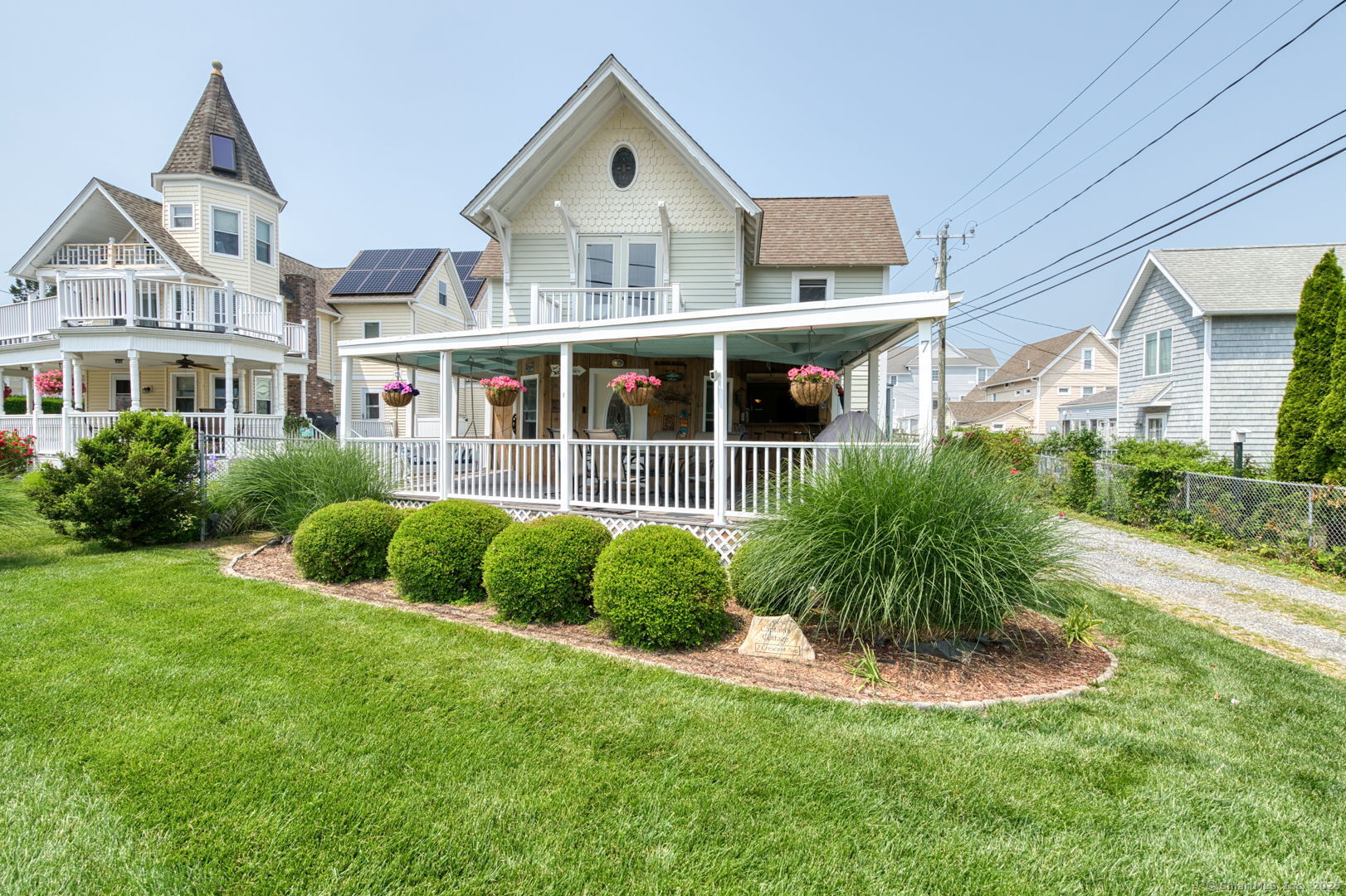a front view of a house with a yard and potted plants