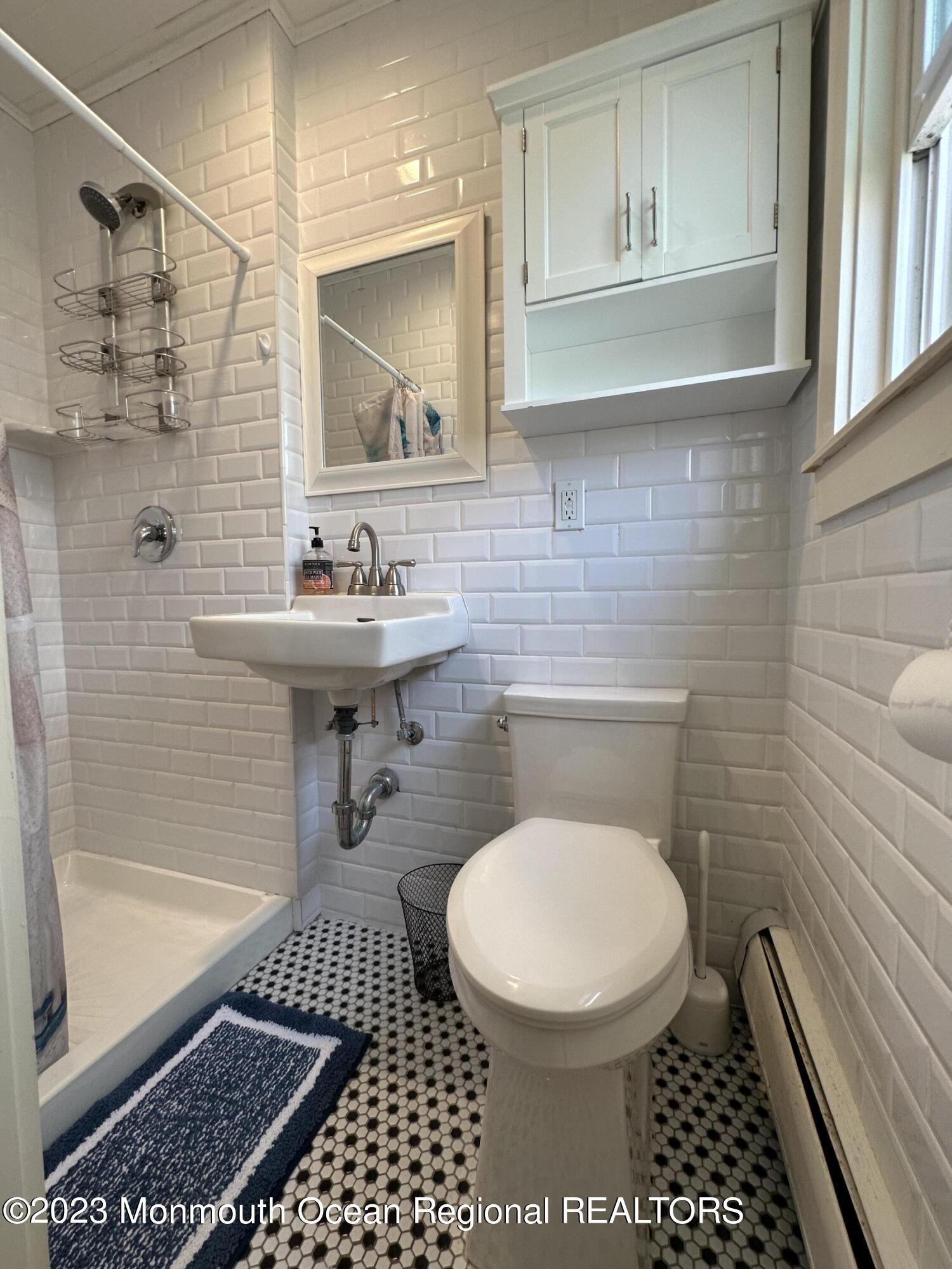 58 5th Street, Unit F Highlands, NJ 07732 - Photo 25 of 33 a bathroom with a toilet a sink and mirror