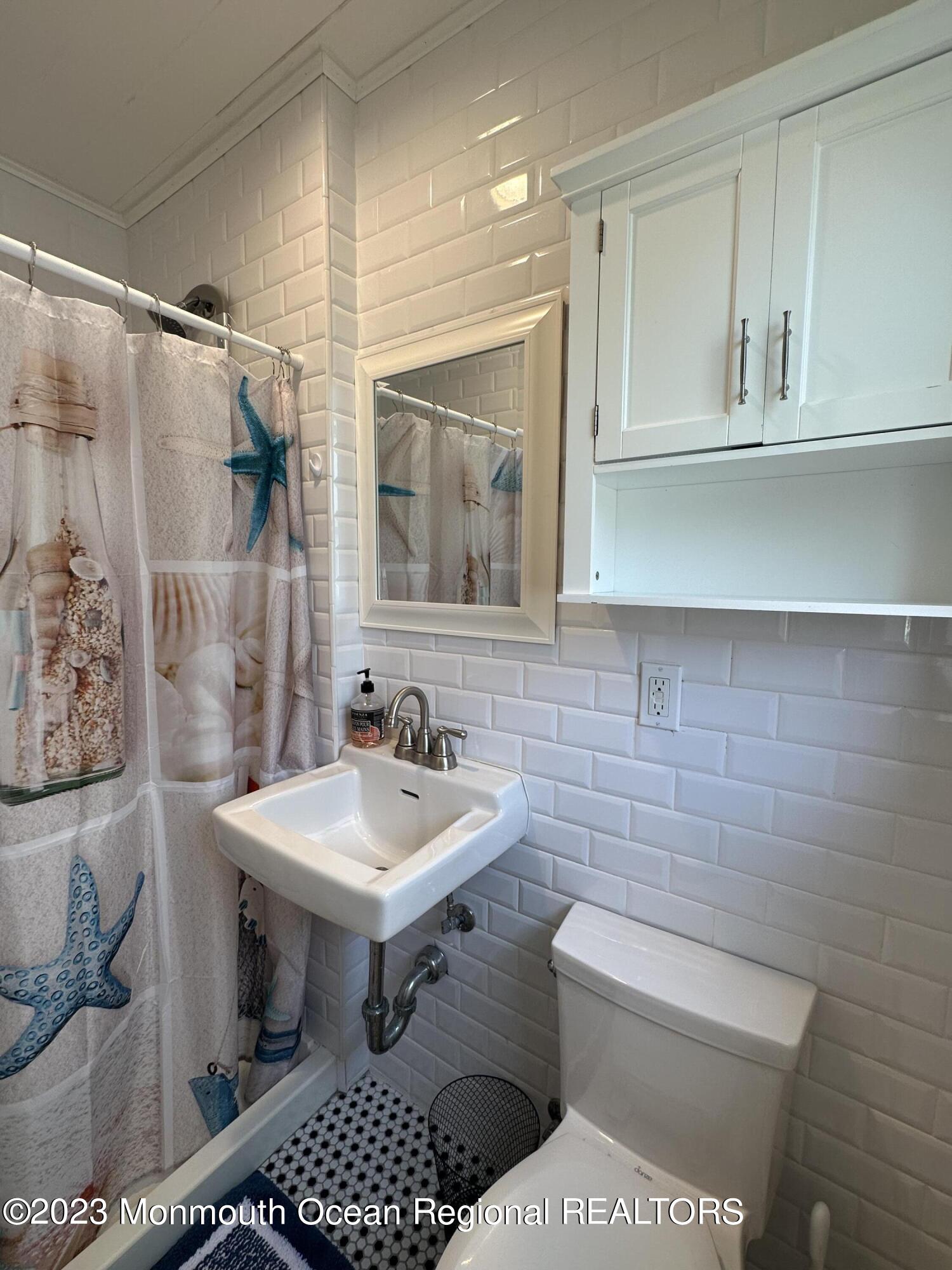 58 5th Street, Unit F Highlands, NJ 07732 - Photo 26 of 33 a bathroom with a toilet a sink and a mirror