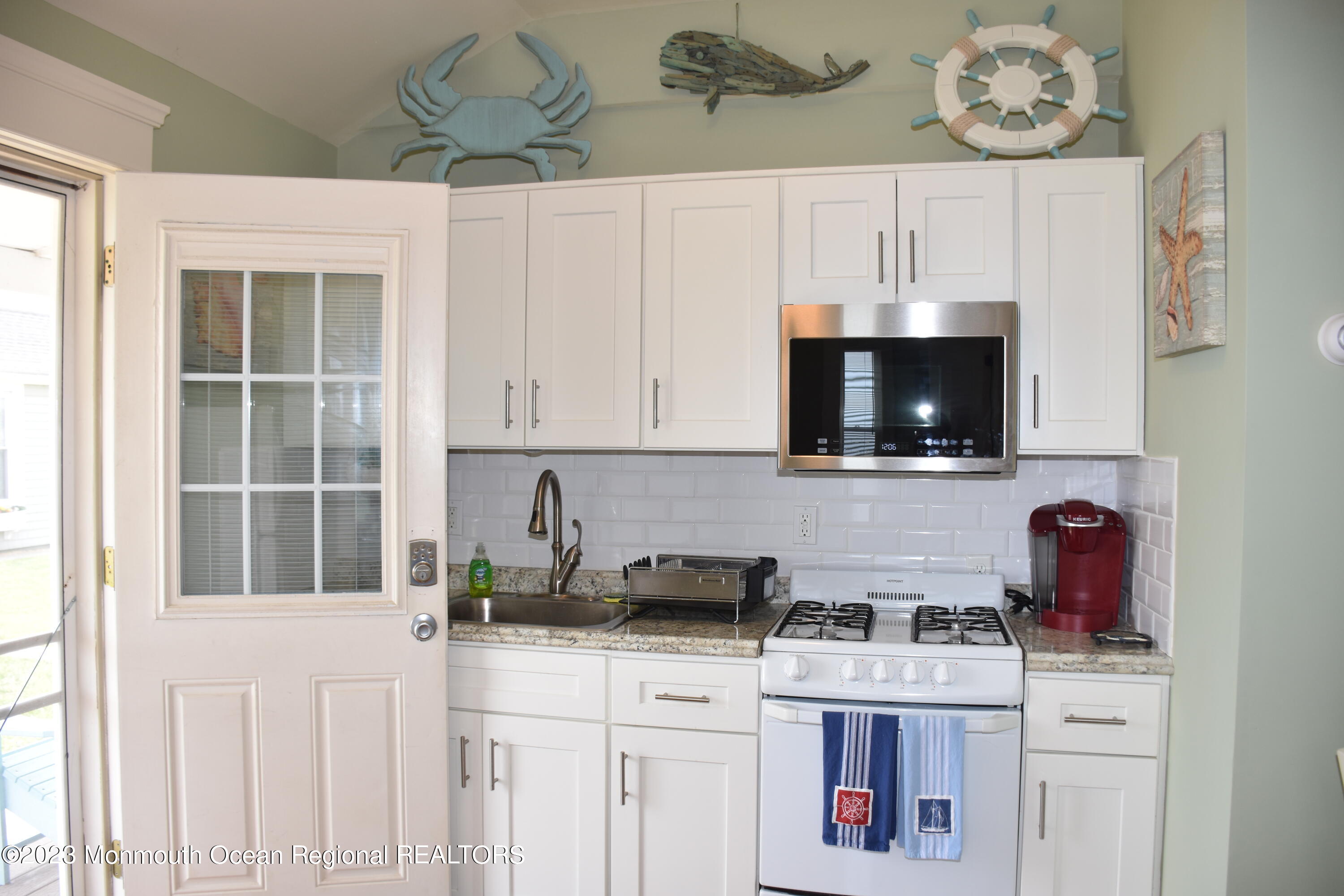 58 5th Street, Unit F Highlands, NJ 07732 - Photo 7 of 33 a kitchen with stainless steel appliances a stove a microwave and cabinets