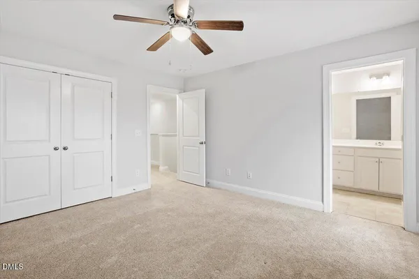 an empty room with closet and a chandelier fan