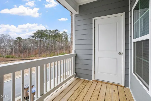 a view of a balcony with wooden floor and fence