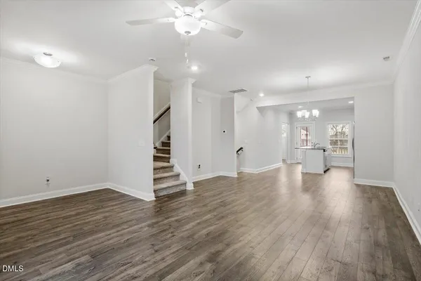a view of an empty room with wooden floor and a fireplace
