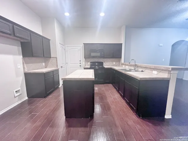 a kitchen with a sink a stove a refrigerator and a microwave