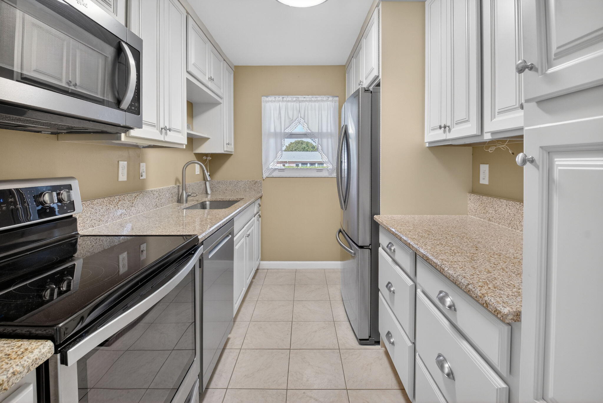 270 High Point Court, Unit D Boynton Beach, FL 33435 - Photo 11 of 41 a kitchen with stainless steel appliances granite countertop a sink and dishwasher a stove top oven with wooden floor