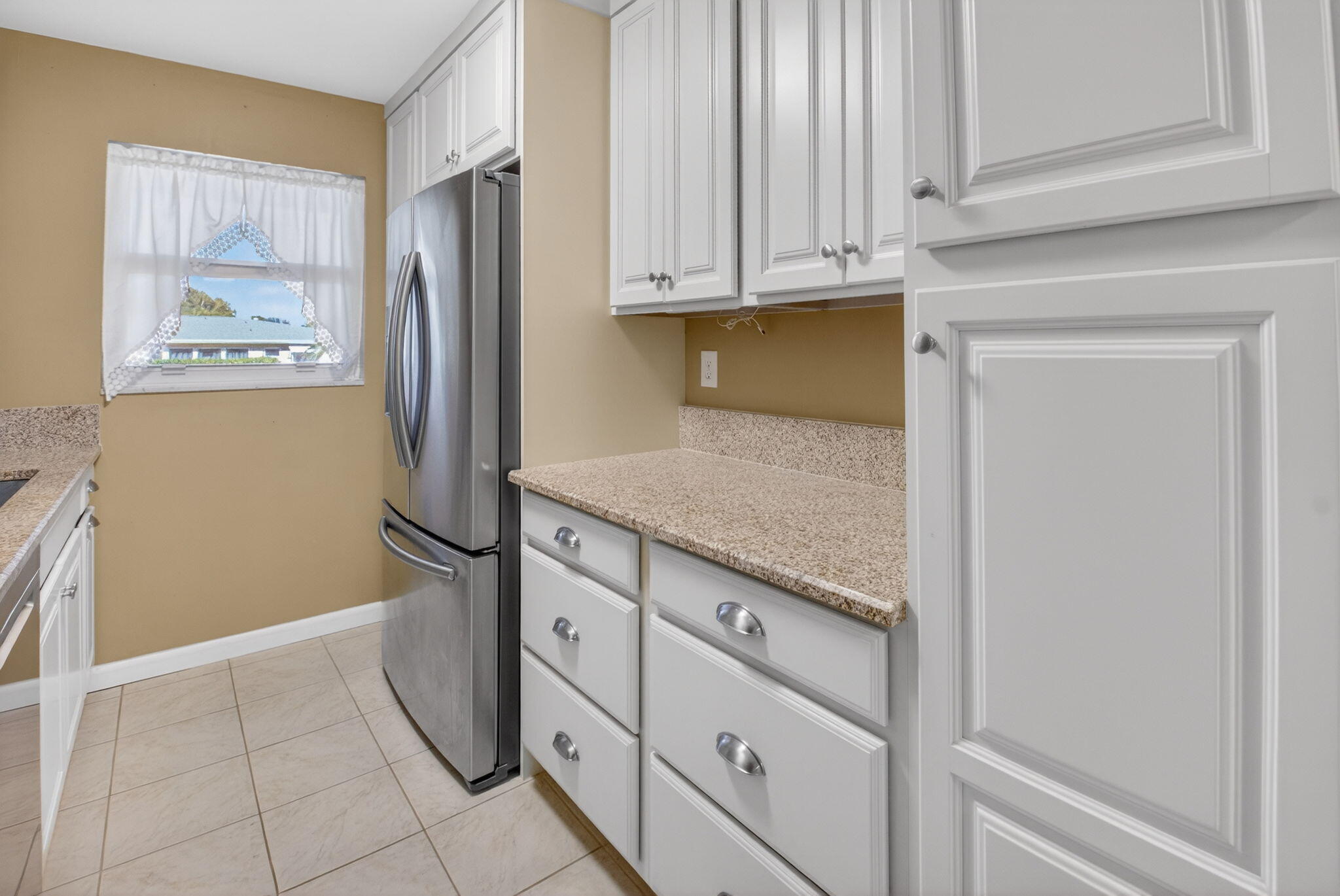 270 High Point Court, Unit D Boynton Beach, FL 33435 - Photo 12 of 41 a kitchen with granite countertop a refrigerator and cabinets