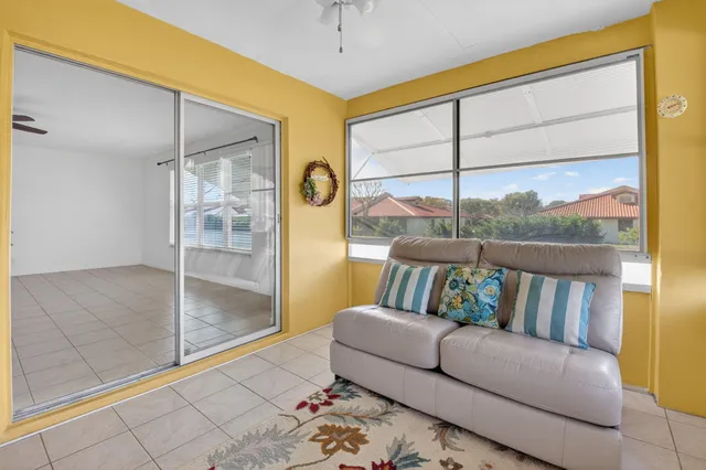 a living room with furniture and a floor to ceiling window