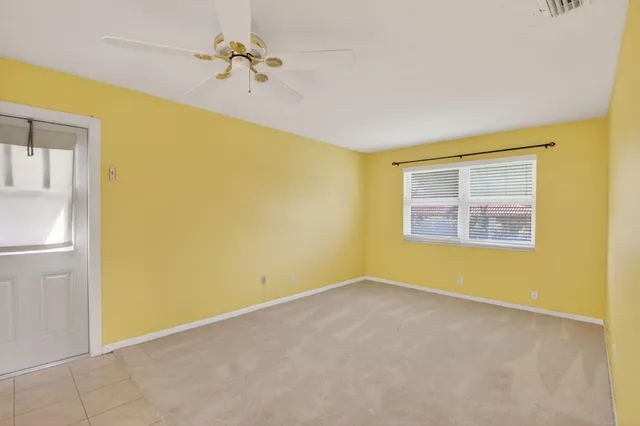 a view of a big room with windows and chandelier fan