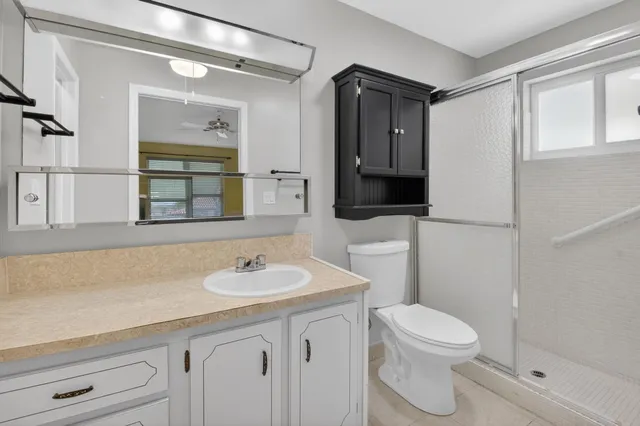 a bathroom with a sink a toilet and shower