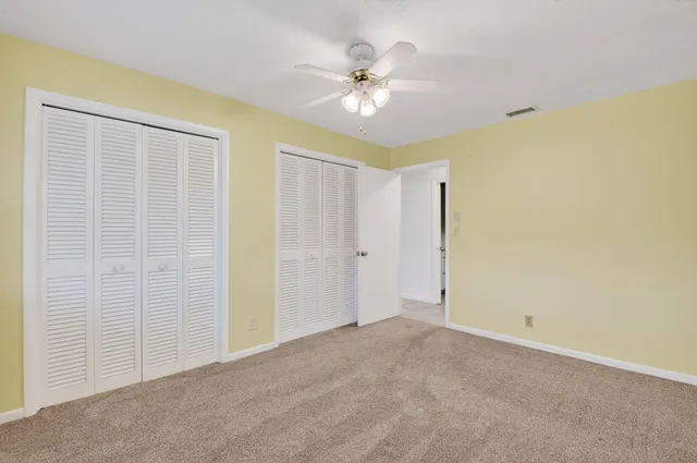 a view of an empty room with a ceiling fan