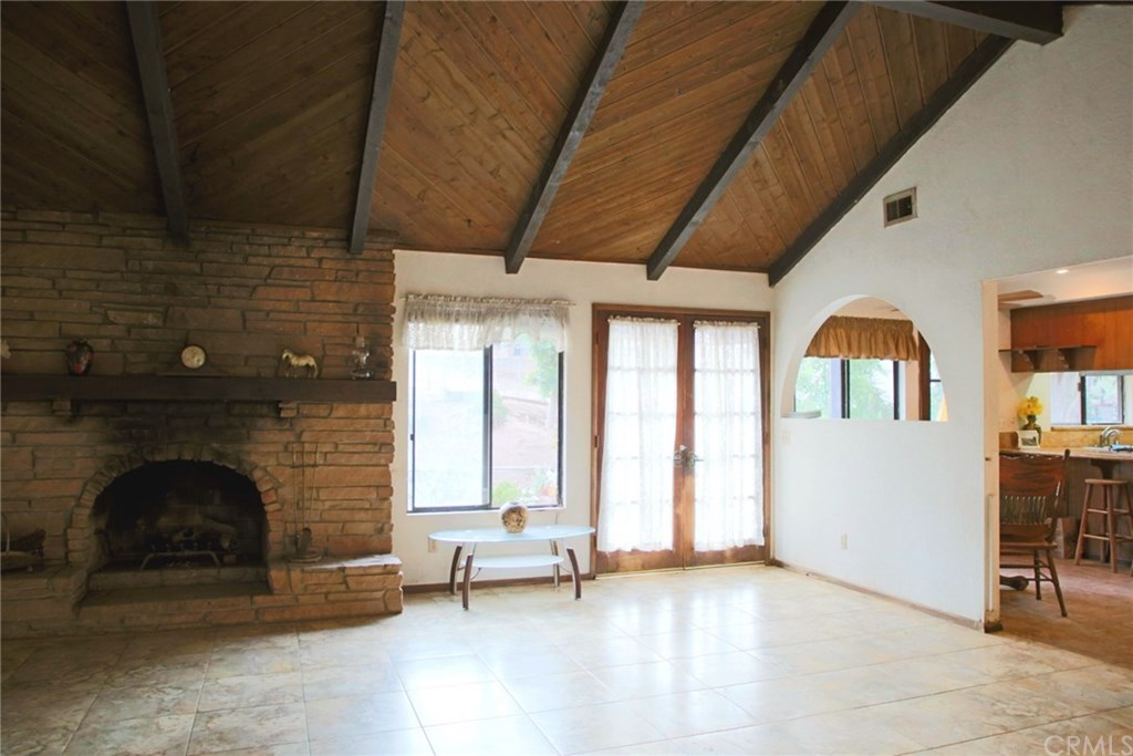6168 Alhambra Avenue Riverside, CA 92505 - Photo 8 of 29 View from foyer into the large family room (18 x 17) with wood and gas fireplace, beamed ceiling, French doors to back patio, and kitchen to the right.