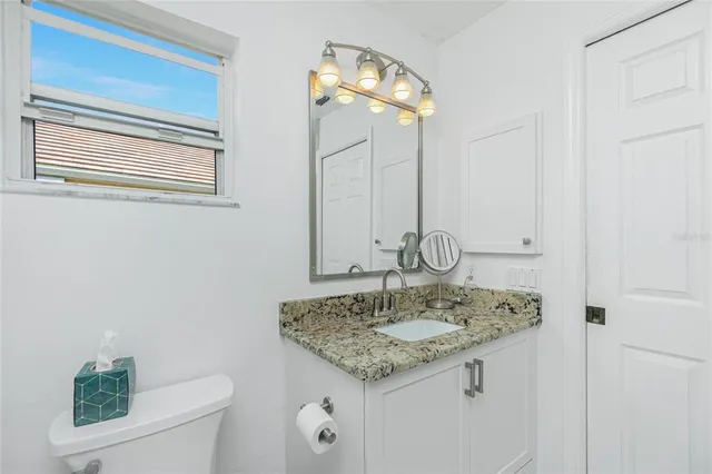 a bathroom with a granite countertop sink and a mirror