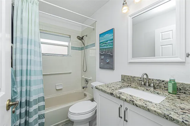 a bathroom with a granite countertop sink toilet mirror and shower