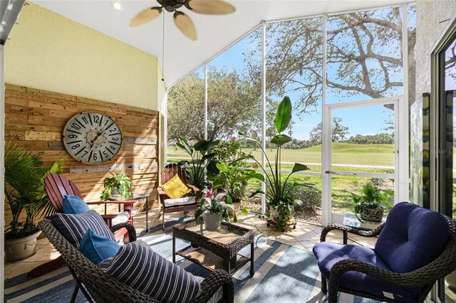 a living room with couches painting on the wall and a potted plant