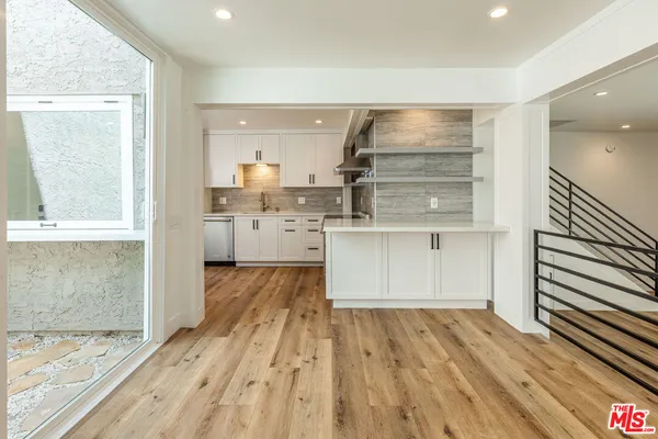 a view of kitchen with wooden floor and electronic appliances