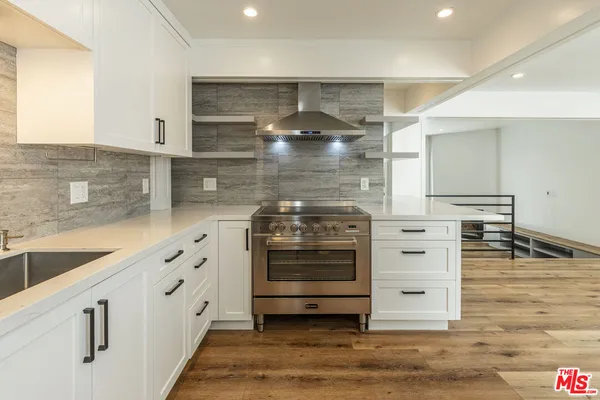 a kitchen with granite countertop a stove and cabinets