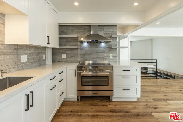 a kitchen with granite countertop a stove and cabinets