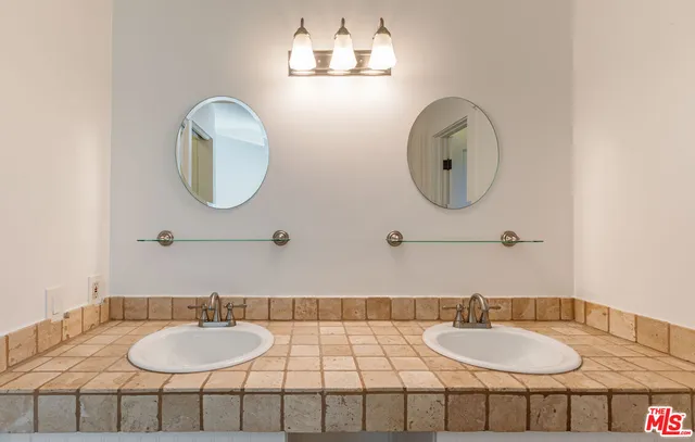 a bathroom with a granite countertop double vanity sinks and a mirror