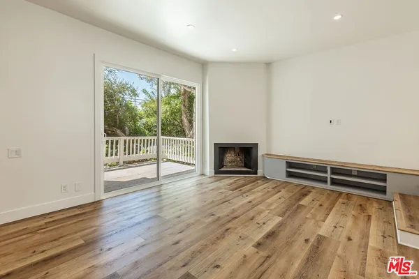 an empty room with wooden floor and fireplace