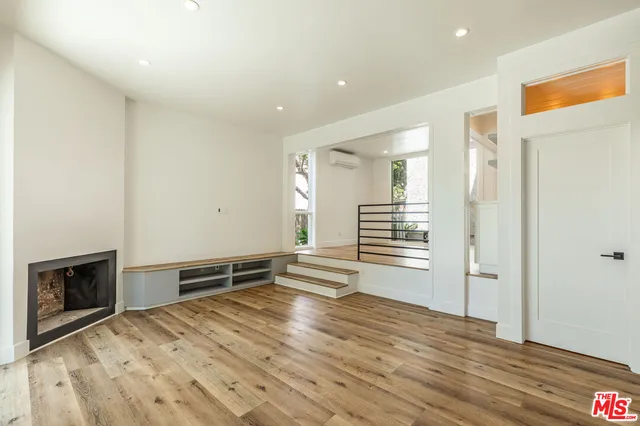 a view of a kitchen with wooden floor and electronic appliances