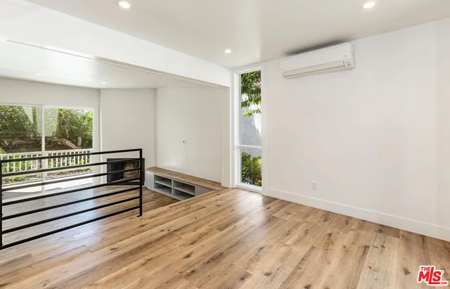 a view of a room with wooden floor and windows