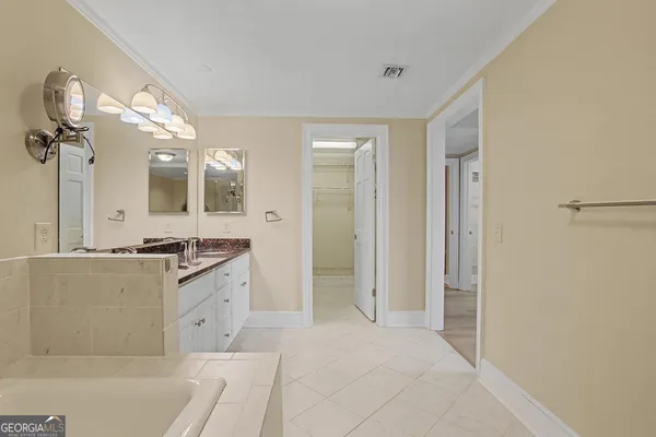 a bathroom with a double vanity sink a toilet a mirror and shower