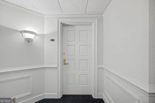 a view of a hallway with wooden floor and a bathroom