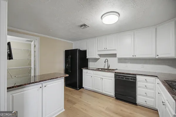 a kitchen with stainless steel appliances granite countertop a refrigerator sink and cabinets