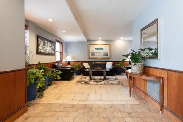 a living room with furniture a potted plant and open kitchen view