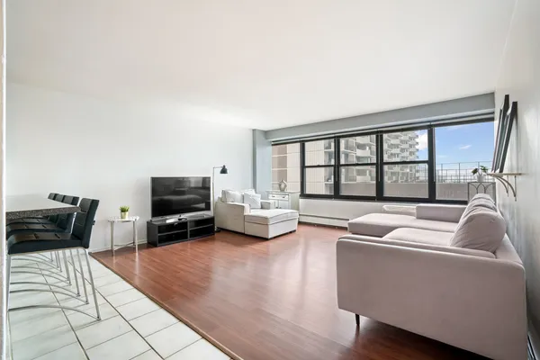 a living room with furniture and a flat screen tv with wooden floor