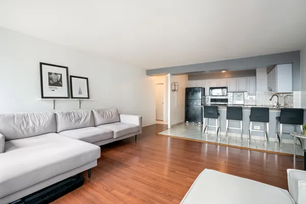a living room with furniture and a view of kitchen