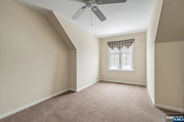 an empty room with a ceiling fan and window