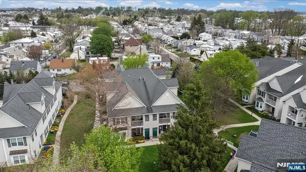 an aerial view of residential houses with outdoor space and trees