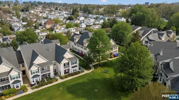 an aerial view of residential houses with outdoor space and trees