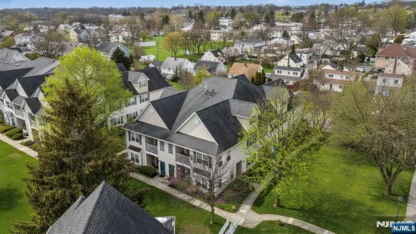 an aerial view of residential houses with outdoor space and trees