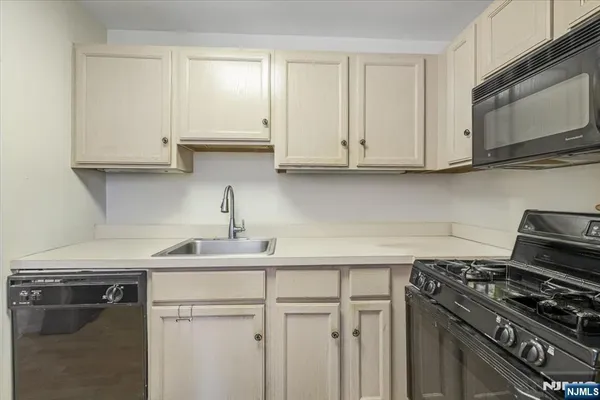 a kitchen with white cabinets and appliances