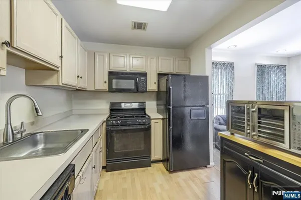 a kitchen with a refrigerator sink and stainless steel appliances