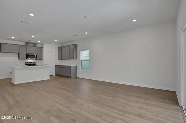 a view of kitchen with wooden floor and electronic appliances