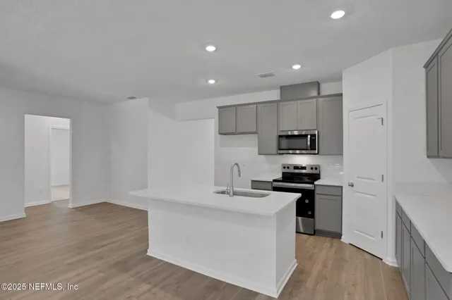 a kitchen with granite countertop a sink stove and refrigerator