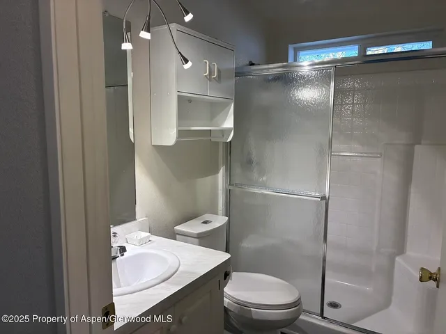 a bathroom with a toilet and a shower