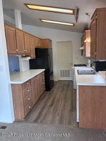 a kitchen with stainless steel appliances granite countertop a sink stove and cabinets