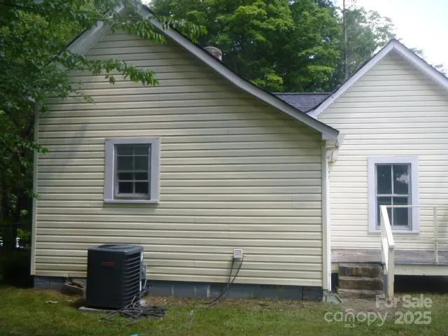 a view of a house with a yard and a large tree