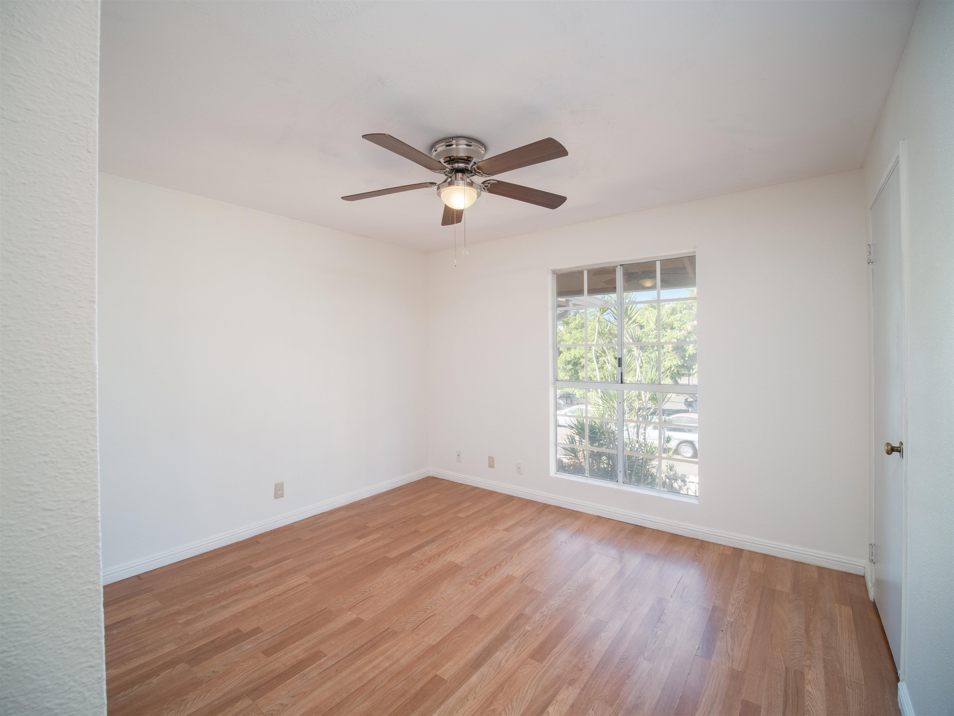 140 Uwapo Road, Unit 43204 Kihei, HI 96753 - Photo 10 of 21 an empty room with wooden floor ceiling fan and windows