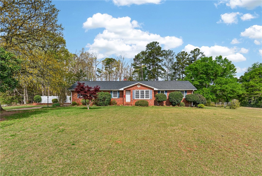 This classic brick residence features a lush lawn and a welcoming facade, perfect for peaceful living.