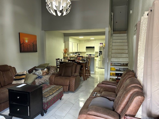 13046 Leader Street, Unit 976 Houston, TX 77072 - Photo 6 of 18 a living room with furniture a chandelier and a flat screen tv