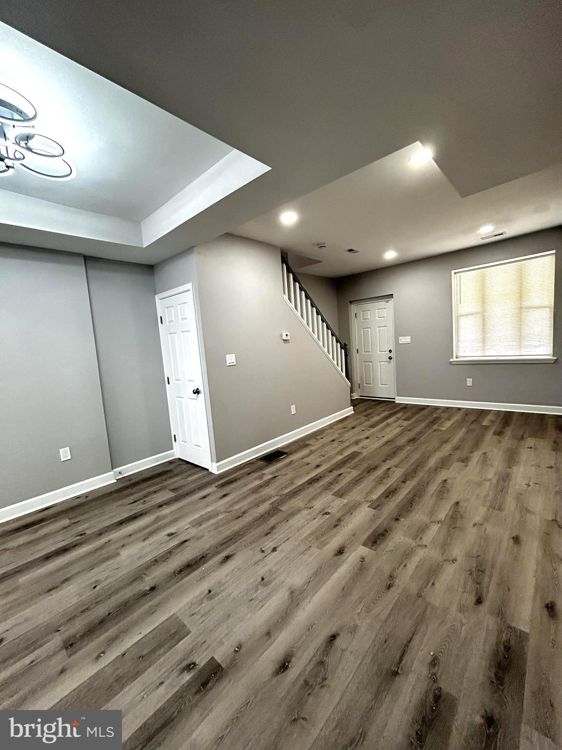 2815 East Chase Street Baltimore, MD 21213 - Photo 13 of 40 an empty room with wooden floor and windows