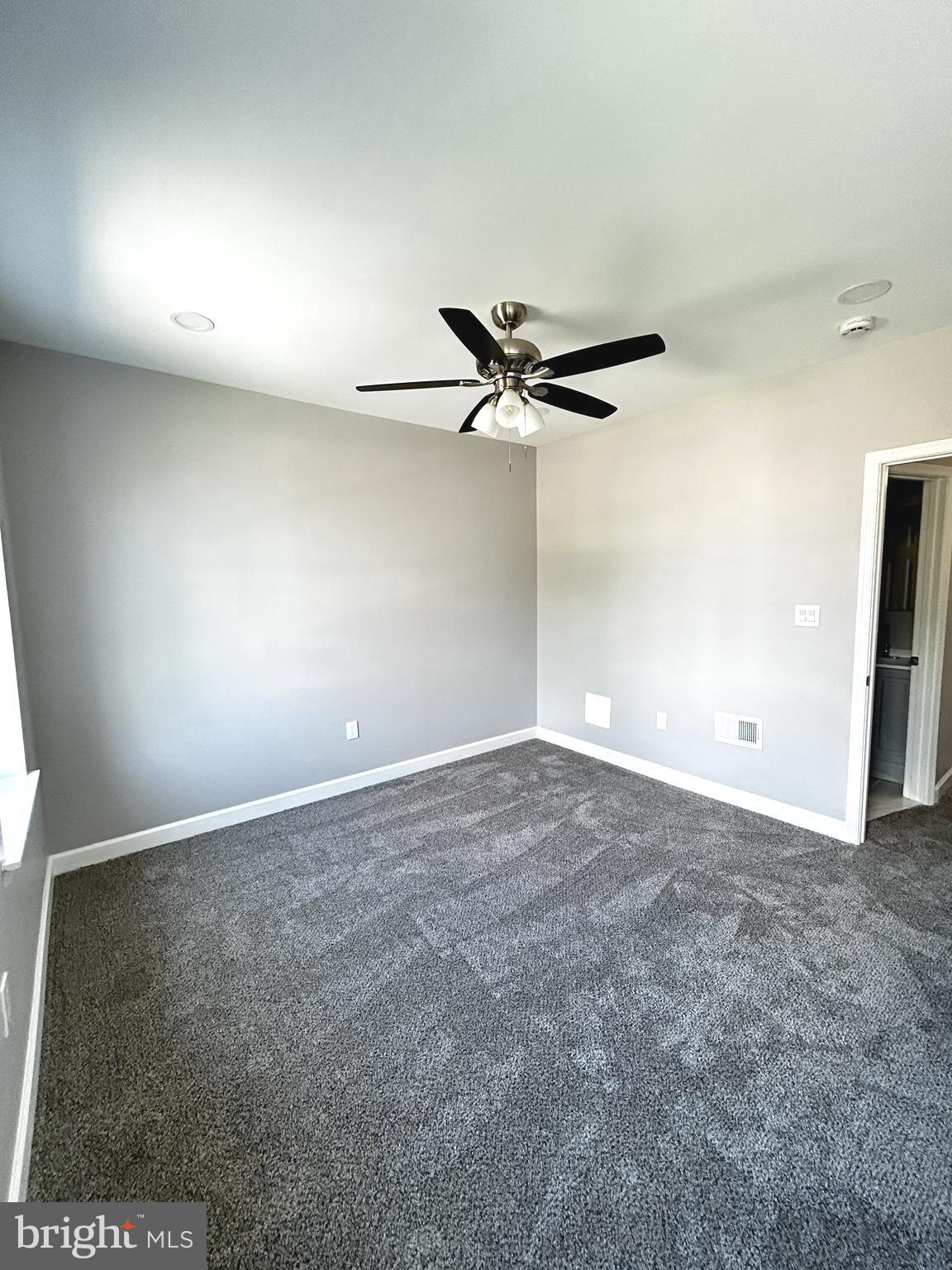 2815 East Chase Street Baltimore, MD 21213 - Photo 33 of 40 an empty room with a ceiling fan and window