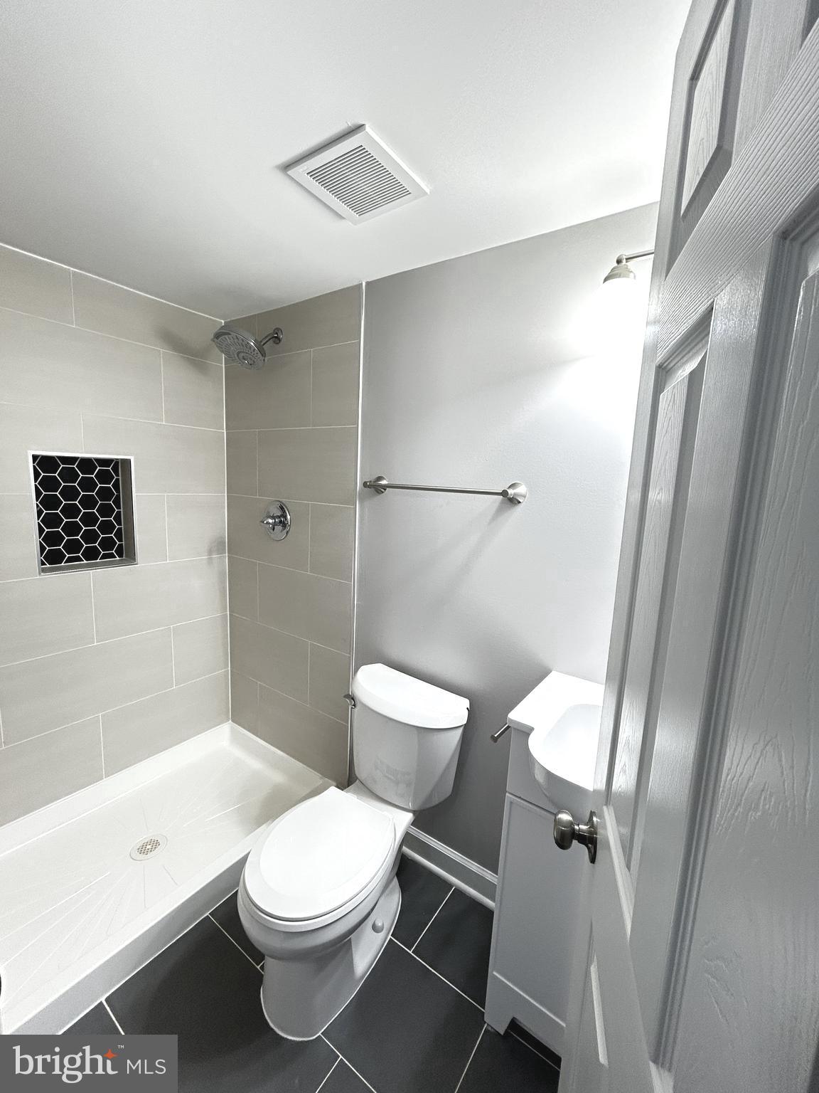 2815 East Chase Street Baltimore, MD 21213 - Photo 34 of 40 a white toilet sitting next to a bath tub shower
