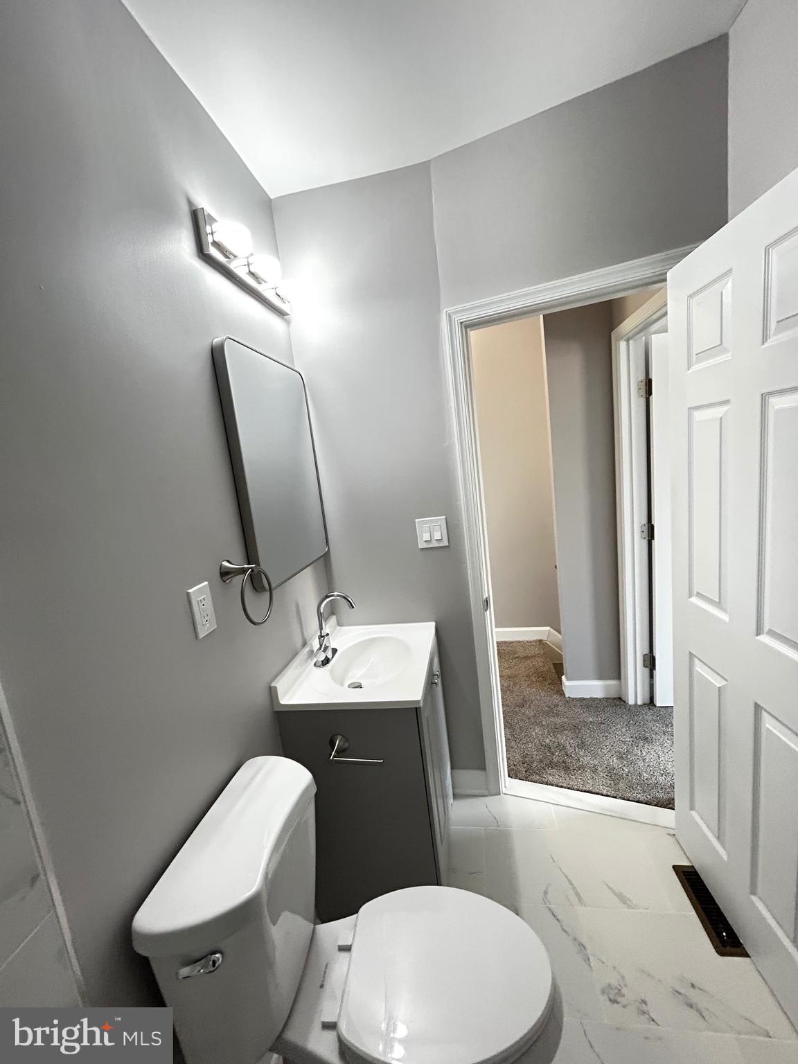 2815 East Chase Street Baltimore, MD 21213 - Photo 39 of 40 a bathroom with a toilet a sink and mirror